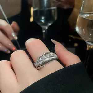 Close-up of a 14k gold plated geometric ring with sparkling cubic zirconia on index finger.