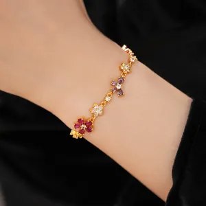 Close-up of elegant gold-plated bracelet with multi-colored zirconia flowers on wrist