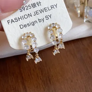 Close-up of elegant 18k gold plated zircon water drop ear clips on a jewelry display card