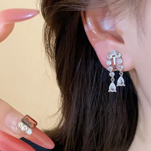 Detailed macro view of 18k gold plated zircon water-drop ear clips shown on ear