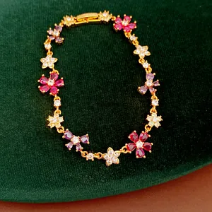 Detailed view of a gold-plated flower and butterfly bracelet with colorful zircons
