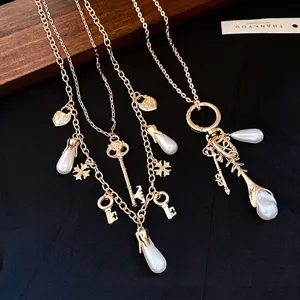 Vintage gold-plated necklace set featuring heart key pendants and elegant teardrop pearls
