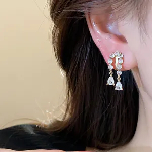 Exquisite close-up of 18k gold plated zircon teardrop ear clips worn on a model earlobe