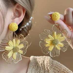 Orecchini pendenti a fiore in rafia gialla e metallo cavo, design di nicchia elegante