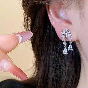 Close-up of elegant teardrop zirconia ear clips shown on a model's ear for detail view
