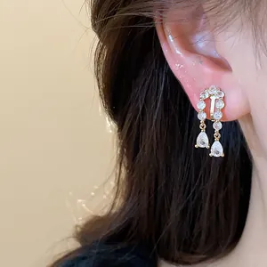 Close-up of 18k gold-plated waterdrop ear clip with sparkling zircons on ear