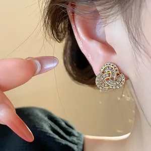 Detailed macro view of 14k gold-plated zircon stud earring in an interlocking knot design