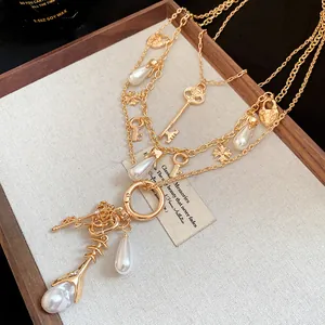 Detailed macro shot of a vintage gold multi-layered necklace featuring pearls and keys
