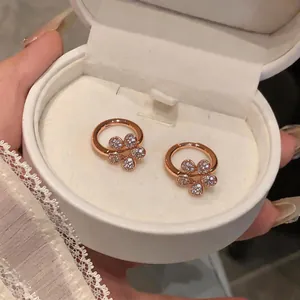 Elegant rose gold flower hoop earrings with sparkling white zircons in a white box