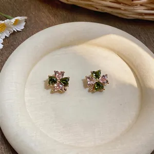 Detailed view of elegant four-leaf clover stud earrings featuring pink and green zircon stones