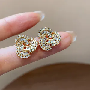 Detailed close-up of 14k gold plated stud earrings featuring pavé zircon knotted heart design