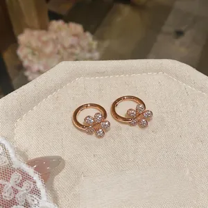 Detailed view of rose gold flower hoop earrings with sparkling cubic zirconia stones