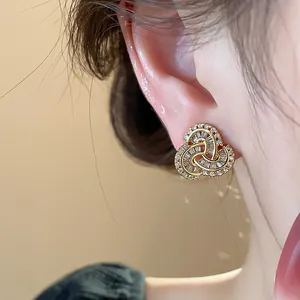 Close-up of 14k gold plated zircon earrings featuring an elegant triple loop design