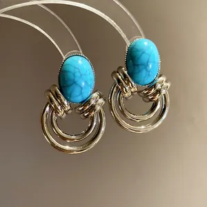 Primo piano di orecchini vintage con turchese ovale, anelli d'argento e stile di corte.