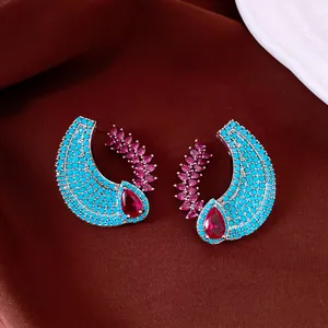 Detailed view of vintage palace style C-shaped earrings with turquoise and magenta stones