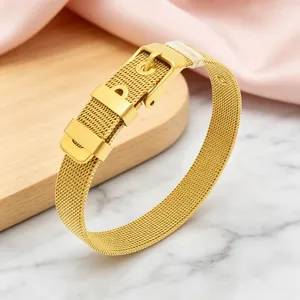 Macro detail of the elegant gold-finished Milanese mesh bracelet with pin buckle.