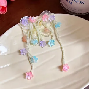 Elegant colorful glass flower tassel earrings with dainty white beads on a plate