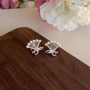 Detailed view of elegant 18k gold plated bow ear clips adorned with pearls and zircons