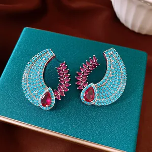 Detailed view of vintage zircon hollow earrings with turquoise and ruby-red stones