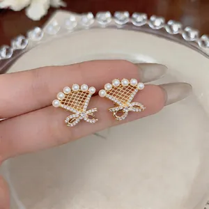 Elegant 18k gold-plated bow earrings with pearls and shimmering zircons detail view