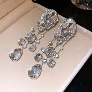 Élégantes boucles d'oreilles pampilles argentées avec strass ovales et poires.