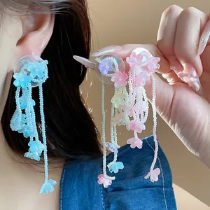 Macro view showing delicate colorful glass flower tassel earrings with long bead strands