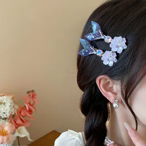 Dettaglio delle eleganti clip per capelli a coda di sirena con perle e strass luccicanti