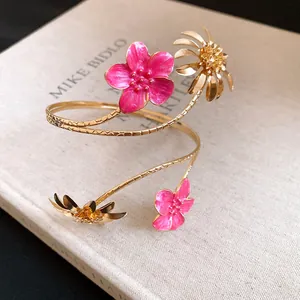 Detailansicht der edlen goldfarbenen Oberarmspange mit rosa Emailleblüten und Dekor