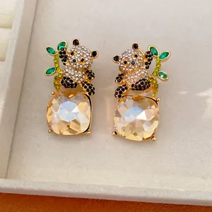 Vista dettagliata di eleganti orecchini a panda in oro con cristalli quadrati champagne