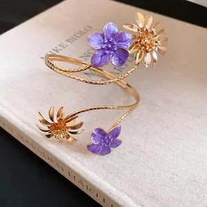 Nahaufnahme des goldenen Oberarmreifs mit violetten Emaille-Blumendetails