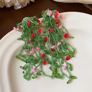 Forest style handmade beaded leaf and flower tassel earrings in green and pink