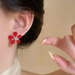 Elegant red flower stud earring with zirconia detailed close-up shot on model's ear