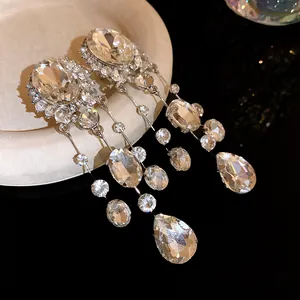 Gros plan de boucles d'oreilles à pompons en strass avec gouttes d'eau