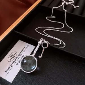 Primo piano della collana con ciondolo a chiave circolare vintage su un vassoio