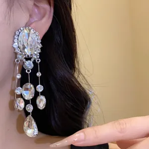 Détail de boucles d'oreilles à franges argentées avec cristaux ovales et en goutte