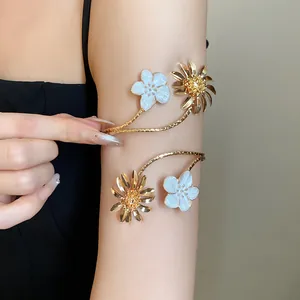 Detailansicht eines goldfarbenen Blumen-Armreifs mit weißer und goldener Emaille-Gänseblümchen.