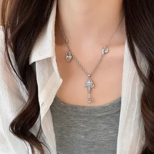Élégant collier avec pendentif clé en argent et zircons brillants porté par un modèle