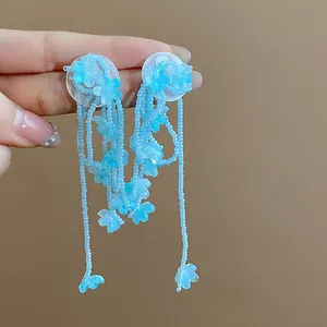 Elegant close-up view of blue glass flower tassel earrings featuring delicate beaded strands