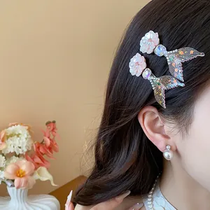 Vista dettagliata di eleganti fermagli per capelli con coda di sirena e fiori su modella