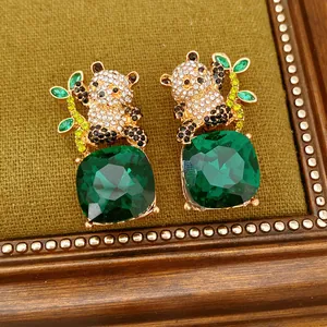 Primo piano dettagliato di orecchini a panda con grandi cristalli quadrati verde smeraldo