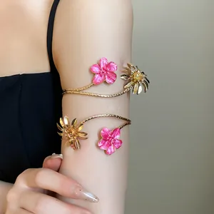 Detailansicht eines goldfarbenen Armreifs mit rosa Emaille- und Metallblumen.