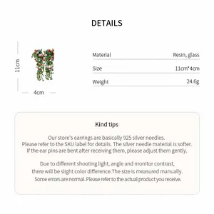 Macro detail of resin floral leaf tassel earrings with product dimensions and weight info.