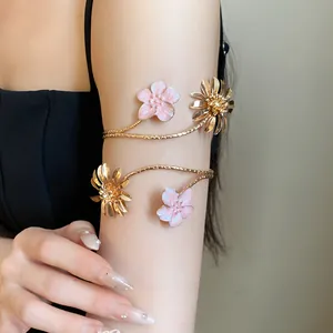 Detailansicht eines vintage Emaille-Blumenarmreifs in Rosa und Gold an einem Arm.