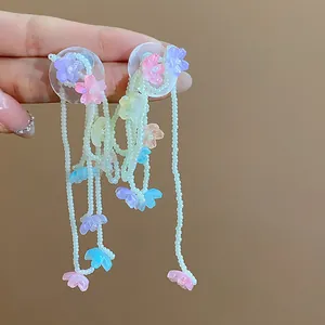 Close-up of colorful glass flower tassel earrings with delicate white beads