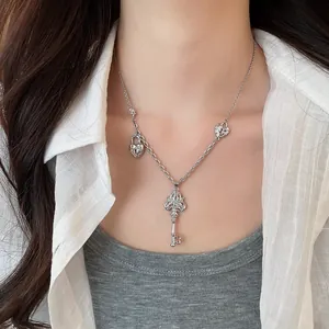 Vue détaillée du collier avec pendentif clé en zircon argenté porté au cou.