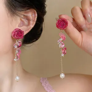 Close-up showing the intricate design of pink rose and pearl tassel dangle earrings