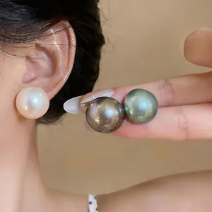 Detailed view of large high-luster faux shell pearl stud earrings in various colors