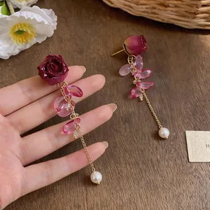 Detail view of elegant dark red rose earrings with pink leaf beads and pearl tassels