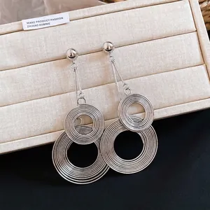 Detail shot of oversized silver metal earrings with concentric textured circles