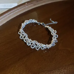 Detailed view of shimmering silver handcrafted beaded bracelet on elegant wooden background.